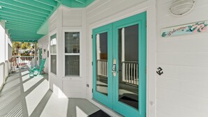 Un bâtiment blanc avec des portes turquoise et une pancarte indiquant « Bienvenue ».