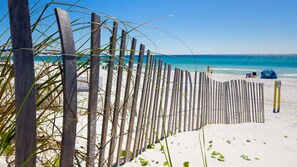 A beach with a wooden fence, a tent, and a sign indicating private property. - Gated Community ~ Lagoon Style Pool ~ Pet Friendly (Destin)