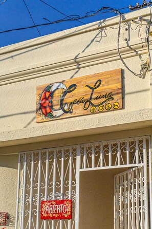 Un cartel con 'Casa Luna' y un letrero que dice 'Taberito' debajo de una reja metálica blanca.