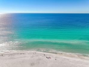 An aerial view of a beach with clear turquoise waters and a sandy shore. - Luxury Destin Retreat | Walk to Beach | 4BR + Pool (Destin)