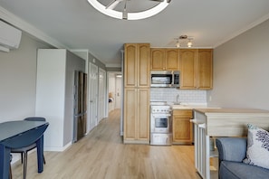A modern kitchen with wooden cabinets, a built-in microwave, and a stove.
