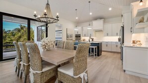 A modern kitchen with white cabinets, a central island, and pendant lighting.