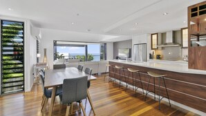 Una cocina moderna con una isla grande, taburetes de bar y vistas al exterior.