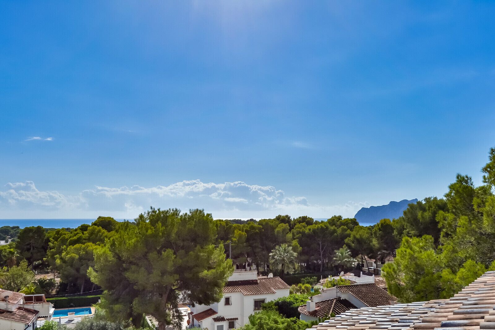 Une zone résidentielle côtière avec des maisons, une piscine et un ciel bleu dégagé.