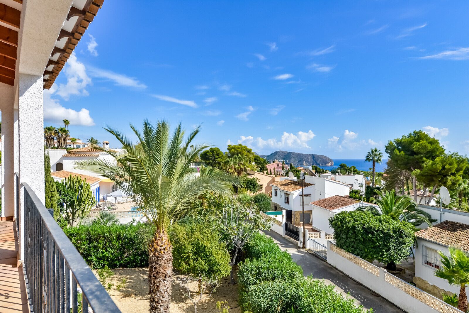 Zona residencial amb vista despejada al mar i una muntanya al fons.
