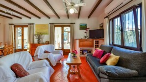 A spacious living room with a ceiling fan, a fireplace, a television, and large windows. - CASABLANCA. Three bedroom villa close to beaches and services in a very quiet area (Calpe)