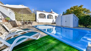 A swimming pool with lounge chairs, a white building with arched windows, and a clear blue sky. - CASABLANCA. Three bedroom villa close to beaches and services in a very quiet area (Calpe)
