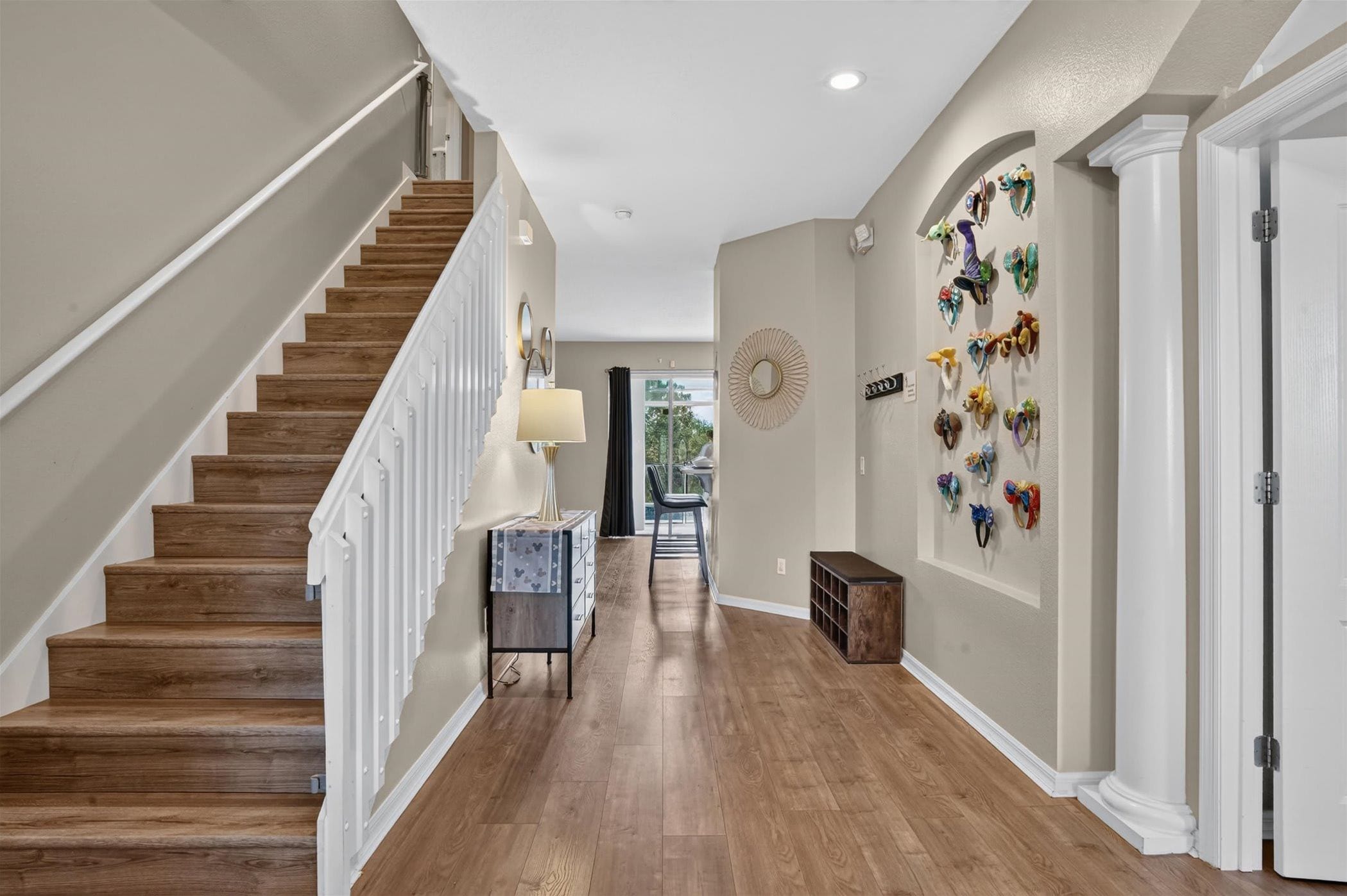 A bright hallway with a staircase and stylish wall decor.