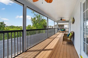 A bright screened porch with comfortable seating and peaceful views. - Disney-Themed Villa with Heated Pool & Playroom (Davenport)
