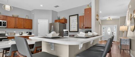 A spacious kitchen with a large island and comfortable bar seating.