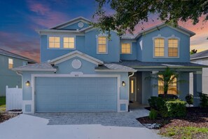 The home beautifully lit up against the evening sky. - Disney-Themed Villa with Heated Pool & Playroom (Davenport)