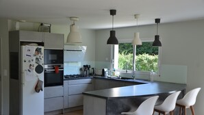 A modern kitchen with a central island, stainless steel appliances, and pendant lighting. - Charming country house (Chamalières-sur-Loire)