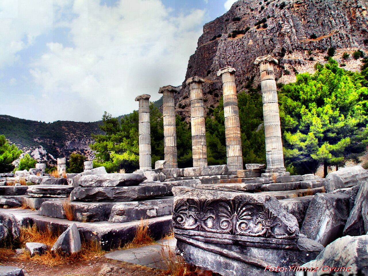 Ruinas antiguas con columnas y tallas en piedra.