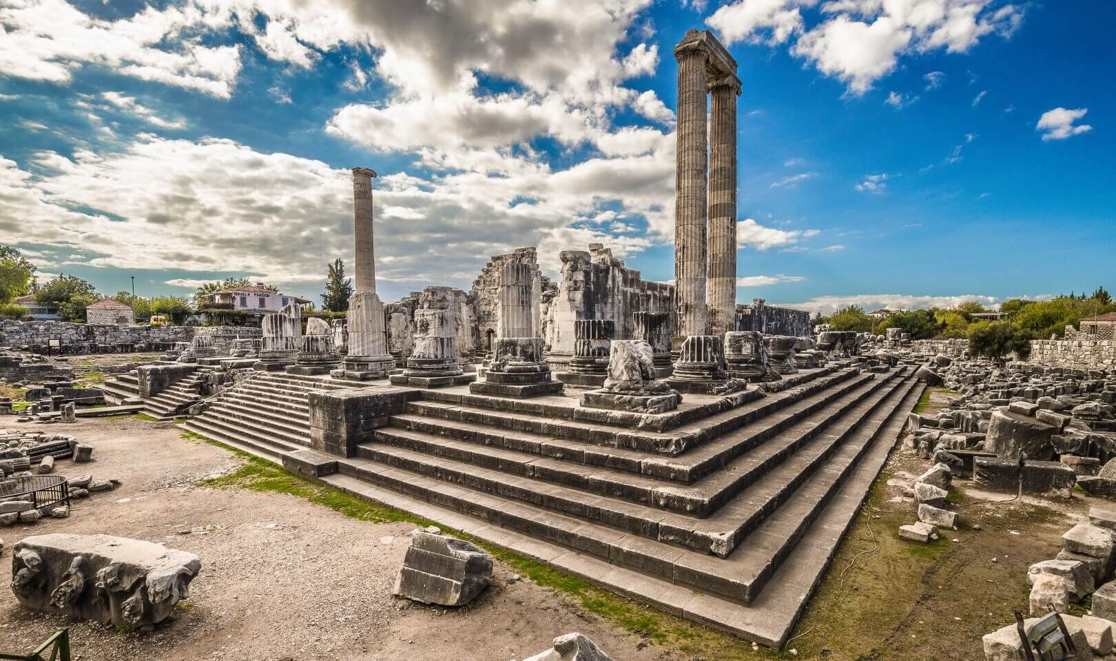 Ancient ruins with columns and steps.