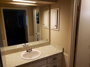 A bathroom with a sink, mirror, and cabinets. - Economy near Baptist Hospital, 2 Bedroom Condo #202 (Oklahoma City)