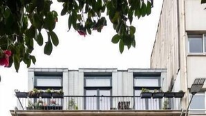 Ein mehrstöckiges Gebäude mit Balkonen, einer Tür mit der Aufschrift „643“ und einer kleinen Außenlounge.