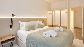 Et pænt indrettet hotelværelse med seng, sengeborde, lamper og et klædeskab.