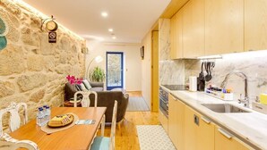 A compact kitchen with wooden cabinets, a marble countertop, and a sink. - *NEW* Riverside 2 Bedroom Apartment by DA'HOME (Porto)