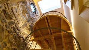A spiral staircase with a stone wall background and a skylight above. - *NEW* Riverside 2 Bedroom Apartment by DA'HOME (Porto)