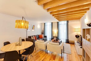 Un salon moderne avec un plafond en bois, une table à manger ronde et un canapé.