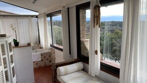 A room with a bed, a window with a view of a landscape, a bathtub, and a small table with a plant. - Gite in Maison d'hôtes in Pays de Fayence - 3 bedrooms Swimming pool, Jacuzzi (Tourrettes)