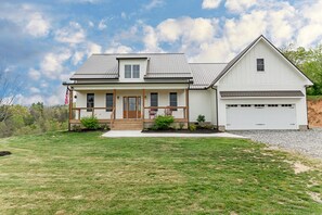 A two-story house with a front porch, a garage, and a well-maintained lawn.