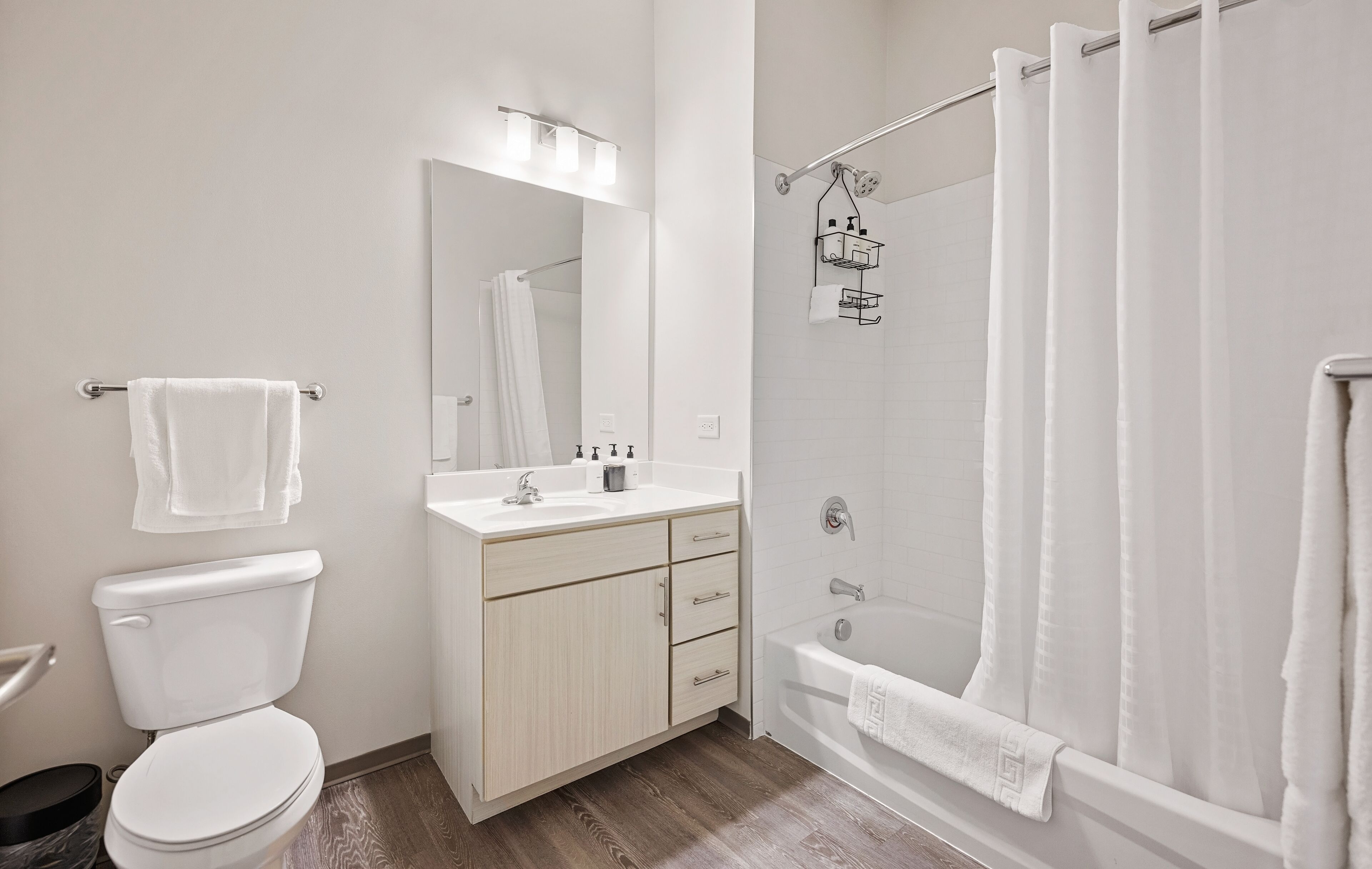 Un baño moderno con inodoro, lavabo, tocador y ducha.