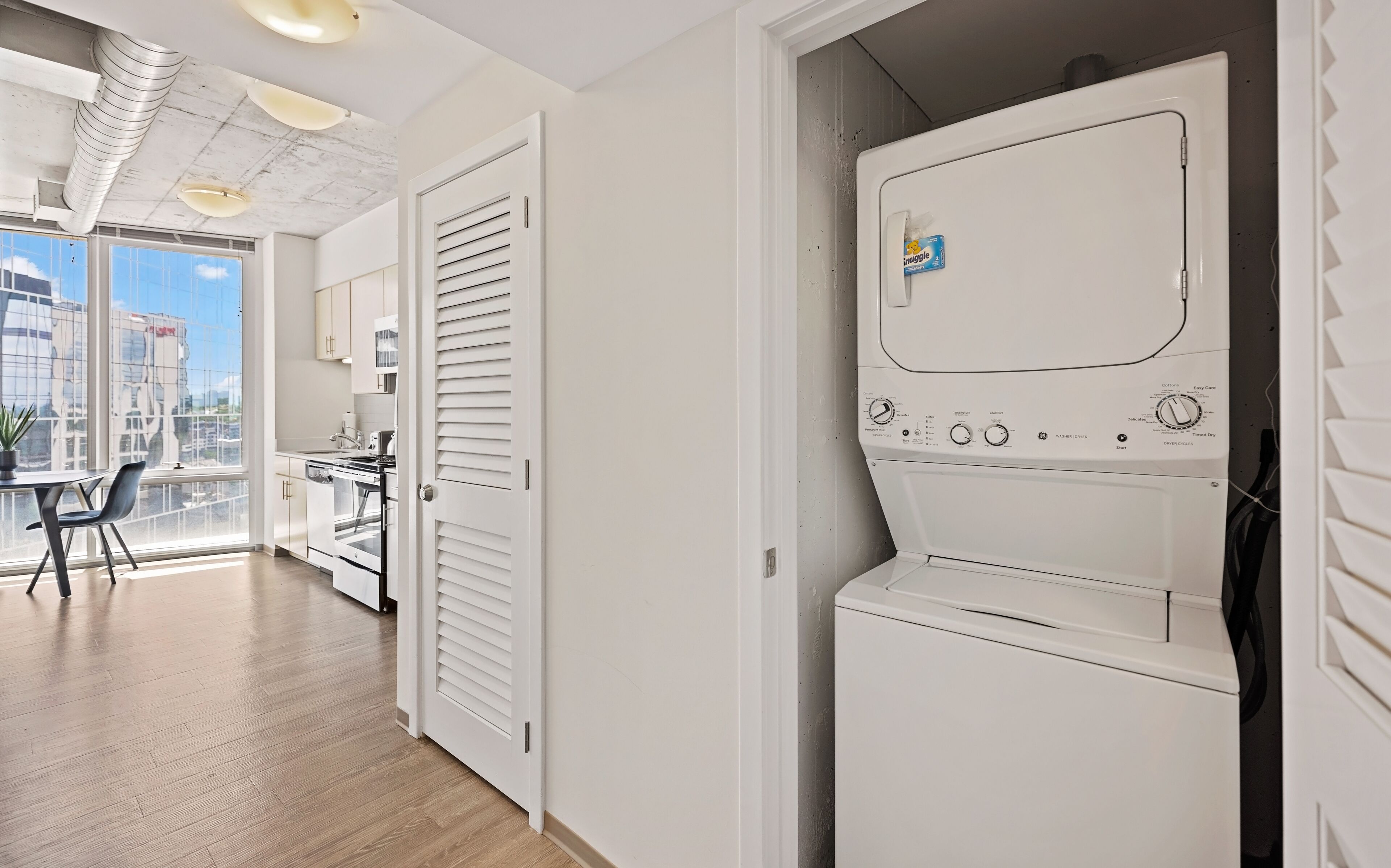 A modern kitchen with a built-in oven and a large window.