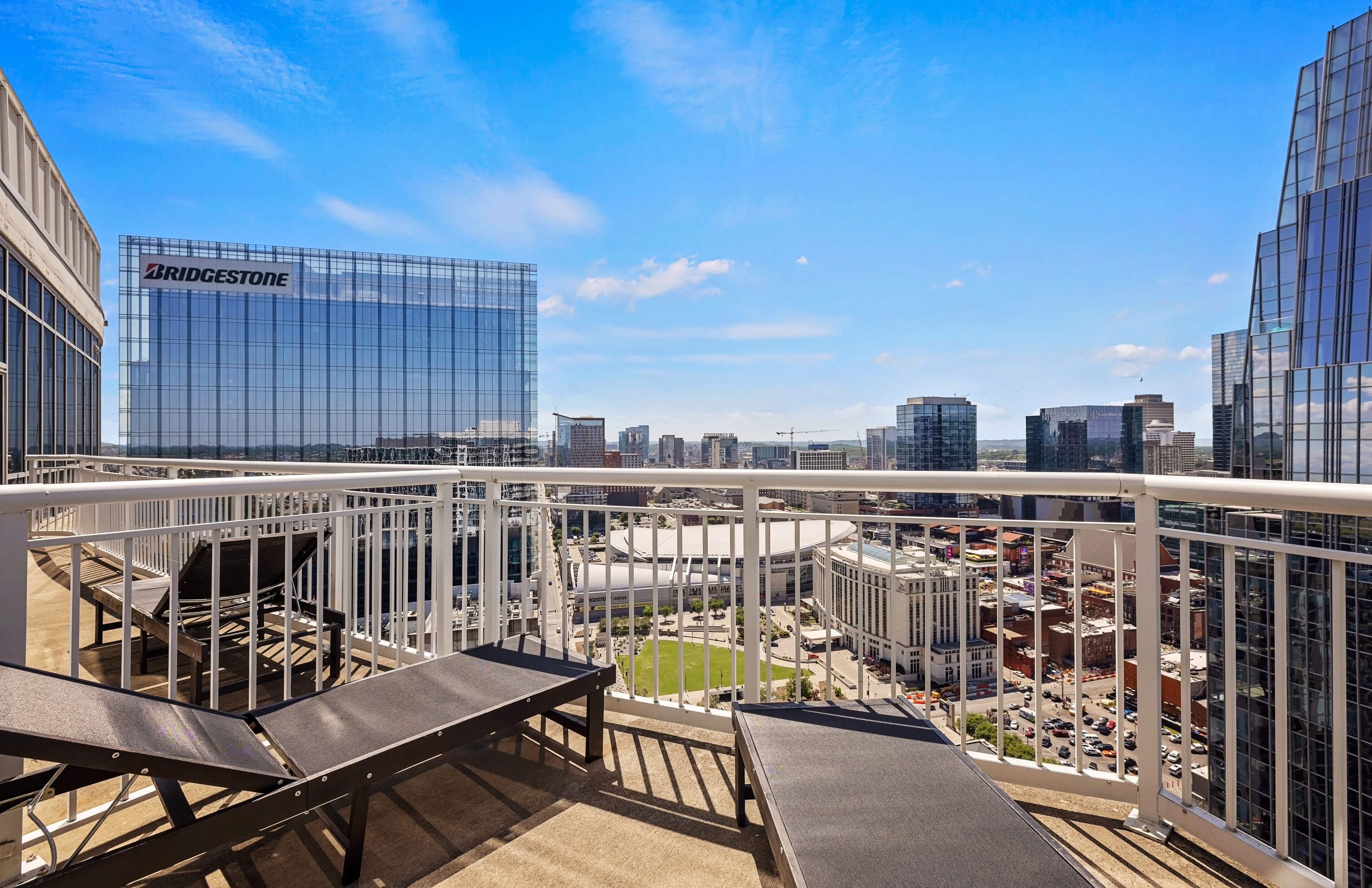 A balcony with a view of a cityscape, including a Bridgestone building.