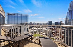 Un balcón con vistas a un paisaje urbano, incluyendo un edificio Bridgestone.