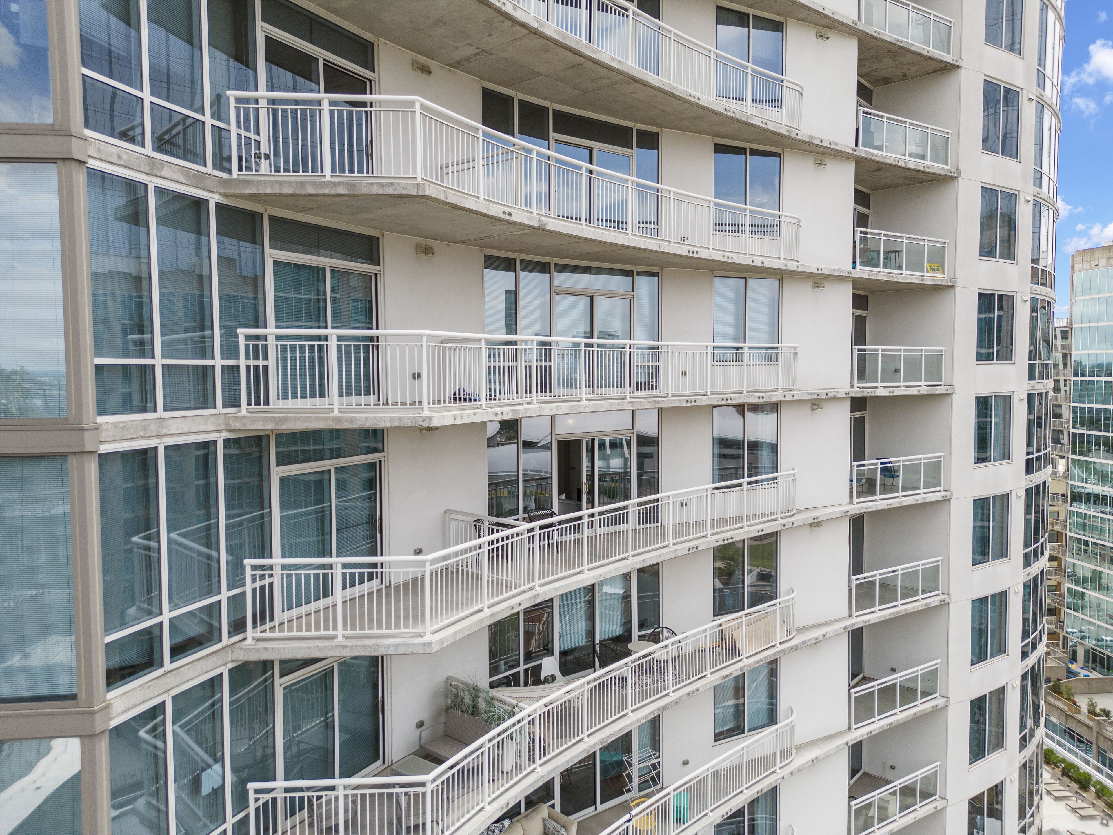 A multi-story building with balconies, large windows, and a modern architectural design.