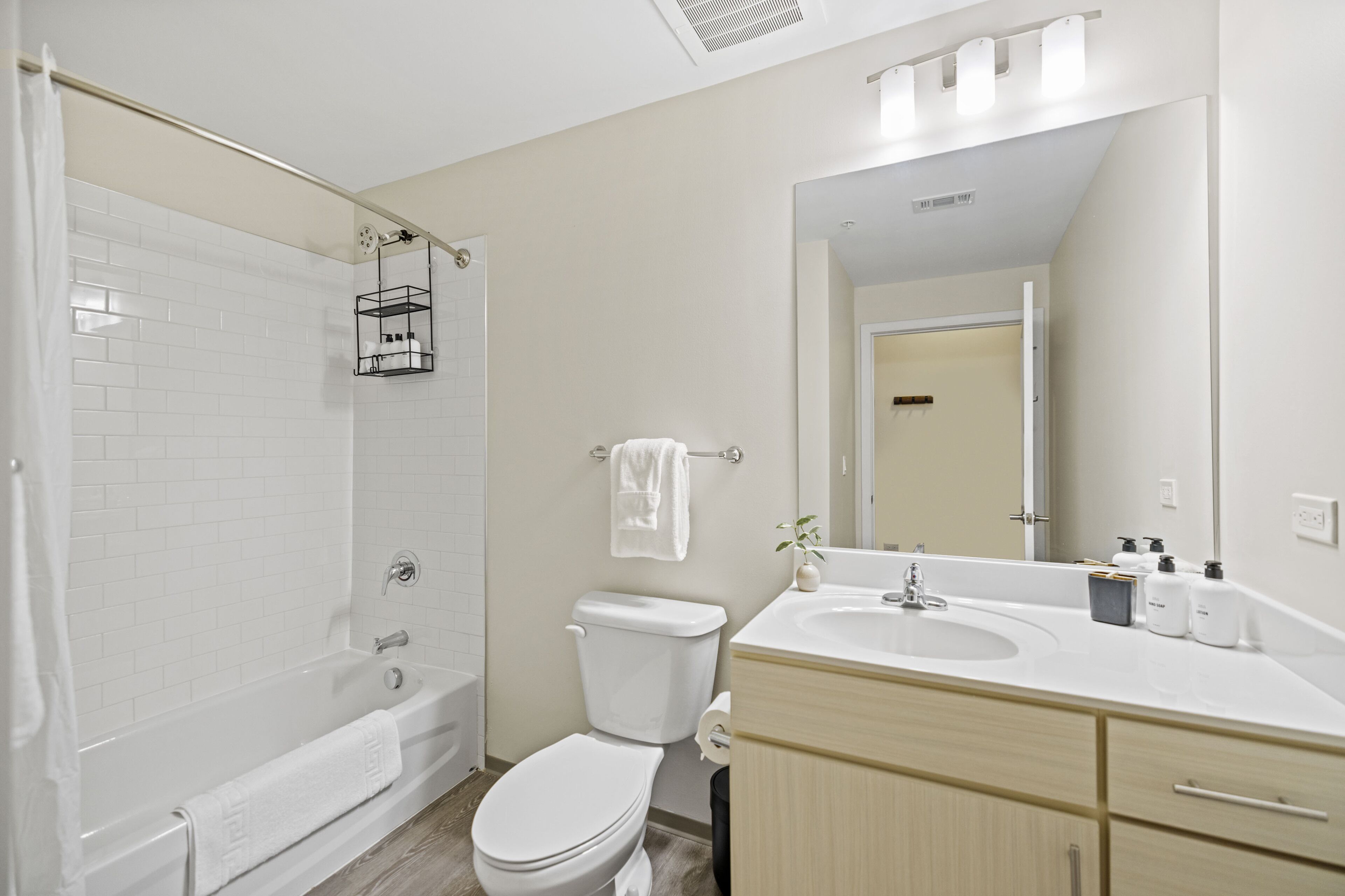 Un bagno moderno con vasca, servizi igienici e lavandino.