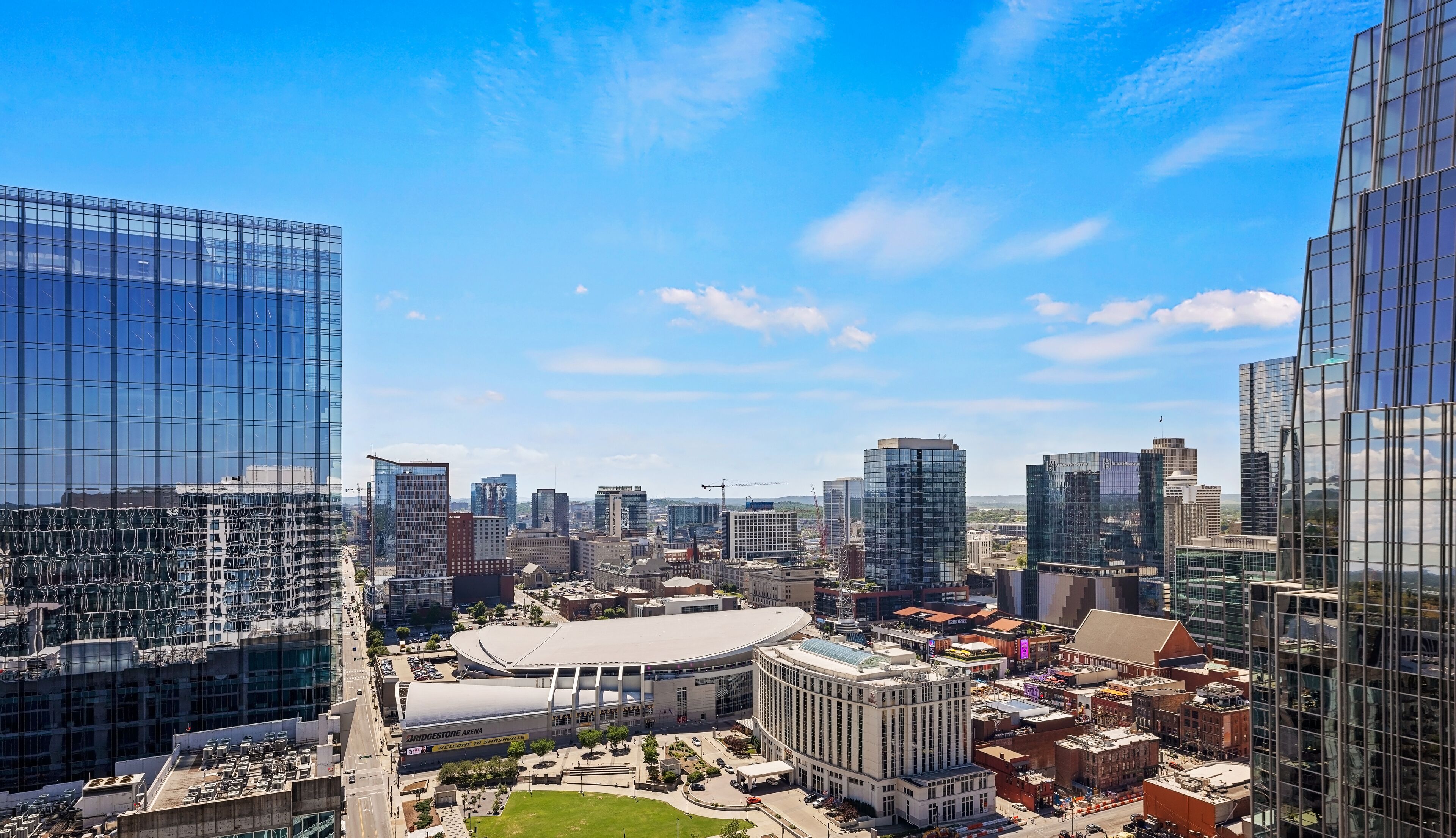 Un paysage urbain avec des immeubles modernes de grande hauteur, un stade et un mélange d’édifices plus anciens.