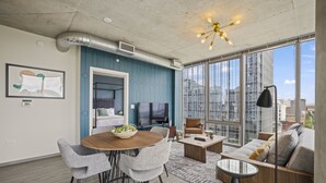 Una sala moderna con comedor, ventanas amplias y vistas a la ciudad.