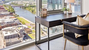Un espacio de oficina moderno con un ventanal grande que ofrece vistas a un paisaje urbano y un río.