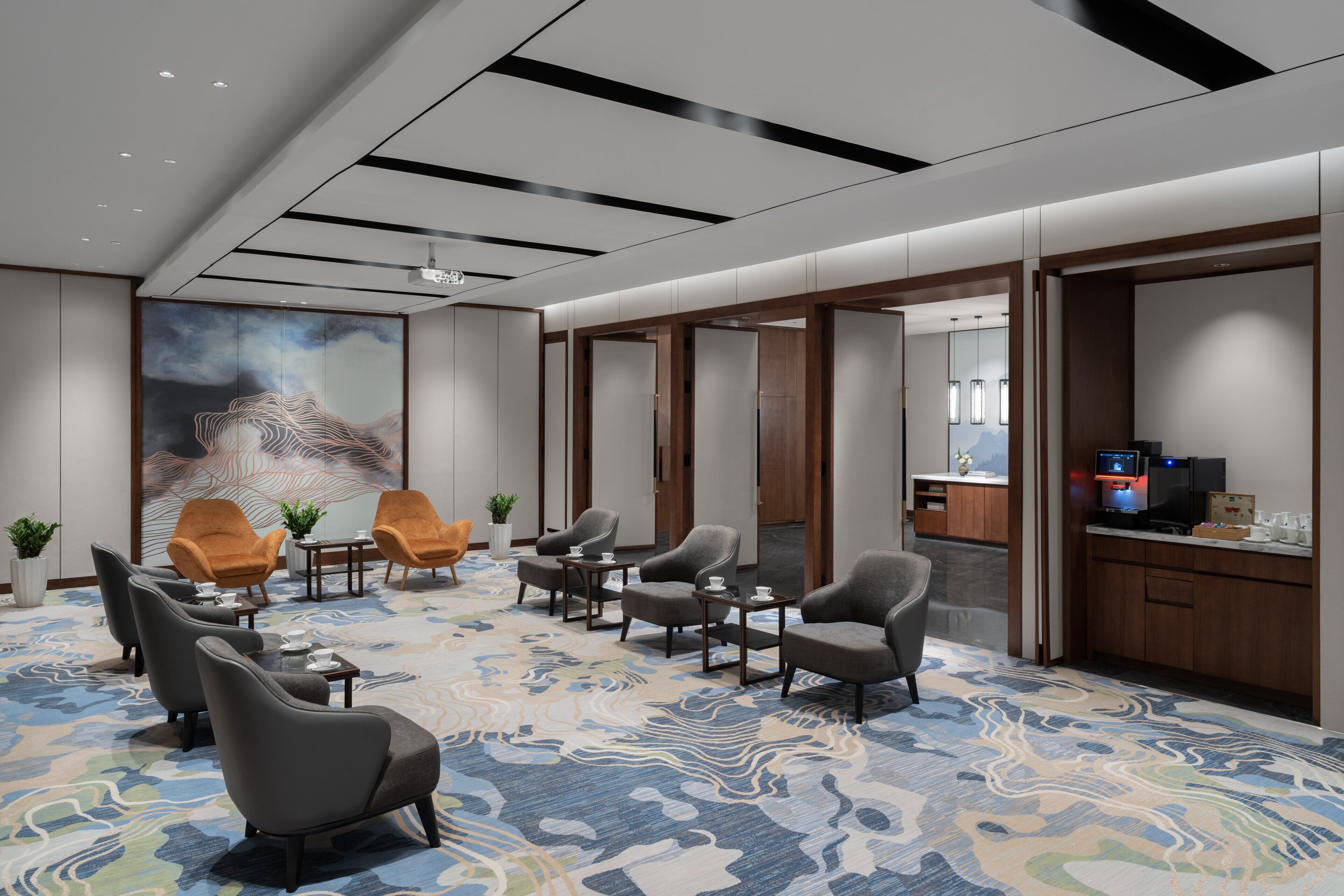 A hotel lobby with seating areas, a large abstract painting, and a reception desk.