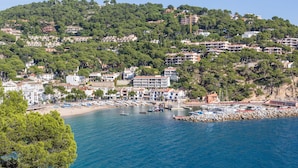 A coastal town with a marina, terraced houses, and a rocky shoreline.