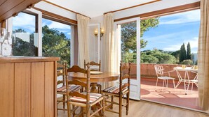 A dining area with wooden furniture and a view of the outdoors. - 1BENET EST - House divided into 3 totally independent apartments with shared pool just 1 km from the beach of Calella de Palafrugell (Calella de Palafrugell)
