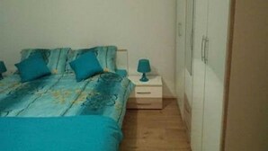 A bedroom with a bed, a nightstand, and a wardrobe. - Apartment Ugljanski Gusari (Preko)