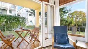Un balcon avec des meubles en bois, une table et des chaises.