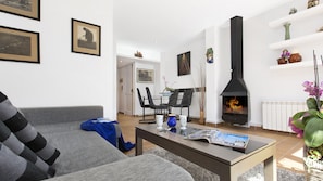 A living room with a sofa, coffee table, and a fireplace.