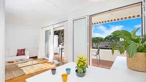 Una sala moderna con sofá, una mesa de centro, una mesa de comedor y un balcón con vistas.