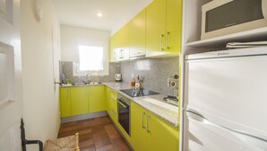 A kitchen with green cabinets, a white refrigerator, and a microwave. - 1MED 17 - Basic apartment in front of the beach of Pals and 100m from the  town centre. (Pals)