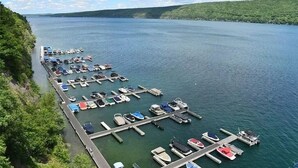 A marina with boats docked along a pier, surrounded by greenery and a calm lake. - Quiet townhome between Canandaigua and Naples in the Finger Lakes (Canandaigua)