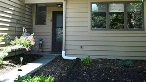 A two-story house with a front door, a small porch area, and a window. - Quiet townhome between Canandaigua and Naples in the Finger Lakes (Canandaigua)