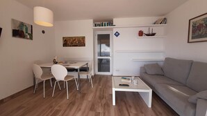 A compact living space with a dining area, a sofa, and a coffee table. - 1BON 2 - Basic apartment for 6 persons in Llafranc, in front of the sea (Llafranc)