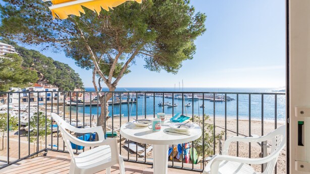 A balcony with white chairs and a table, overlooking a marina with boats and a beach. - 1BON 2 - Basic apartment for 6 persons in Llafranc, in front of the sea (Llafranc)