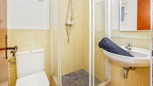 A bathroom with a toilet, a shower with a glass door, and a sink with a towel. - 1BON 2 - Basic apartment for 6 persons in Llafranc, in front of the sea (Llafranc)