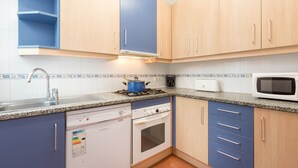 A kitchen with a dishwasher, stove, microwave, and blue cabinets. - 1BON 2 - Basic apartment for 6 persons in Llafranc, in front of the sea (Llafranc)