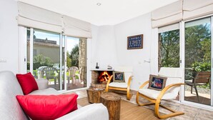 A living room with a sofa, two rocking chairs, a coffee table, and a fireplace. - 1DIAZ 01 - Lovely and cozy villa with private pool and garden situated in a quiet residential area only 1km from the beautiful Aigua Xelida beach (Tamariu)